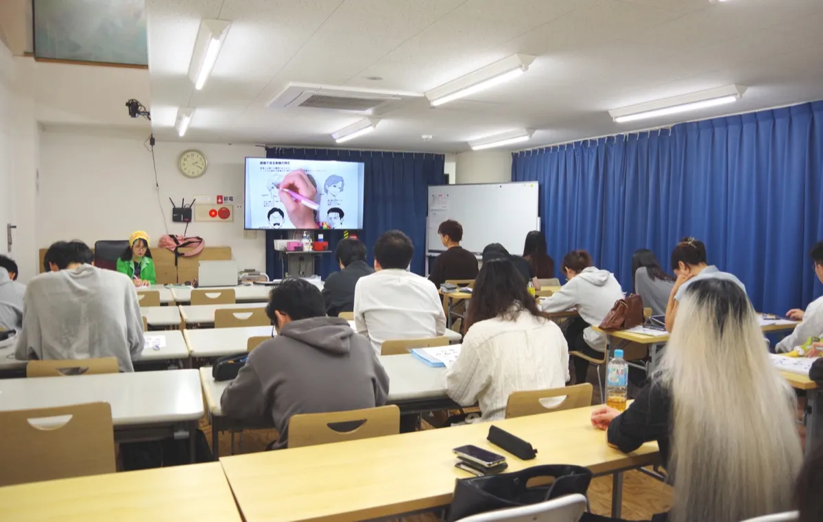 大きな画面を使った講義を受ける学生たち
