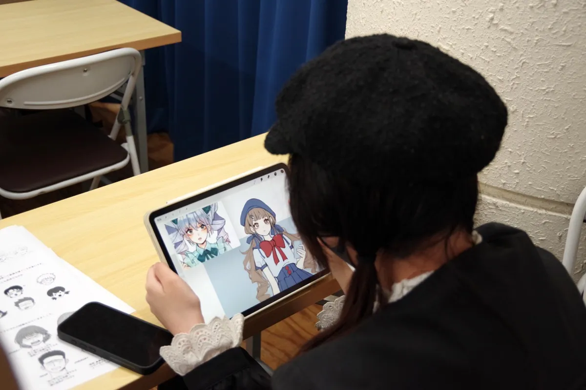 タブレットでキャラクターを描く学生